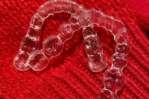 Zwei Invisalign Zahnschienen auf rotem Wollstoff