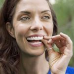 Frau mit Invisalign Zahnspange im Mund