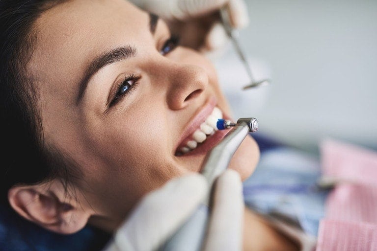 Die Zähne einer hübschen Frau werden professionell, zahnärtzlich gereinigt